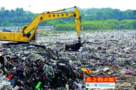 昨日，在从化鳌头镇中塘村“垃圾池”旁，一台钩机正在将垃圾挖上来。南都记者 黎湛均 摄