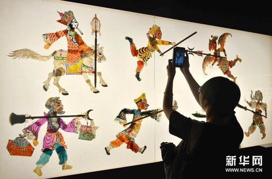 9月20日，参观者在中国美院民艺博物馆拍摄《西游记》相关皮影作品
