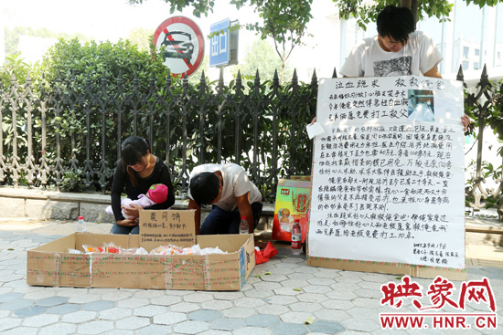 两位年轻的兄弟跪在路边为救患重病父亲，售卖爱心人士捐赠的月饼，引得路人围观捐助。