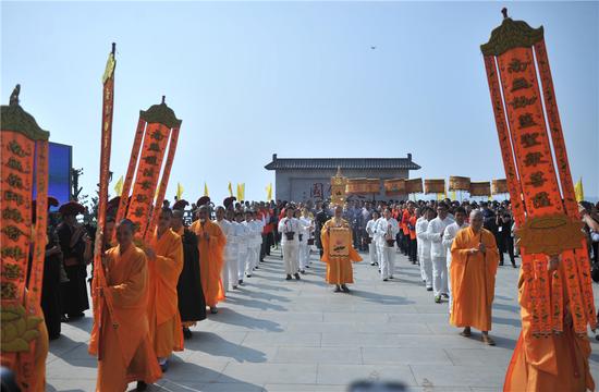 舍利宝塔来到本老手书“中天佛国”石壁前，队伍整齐，尽展佛门威仪。
