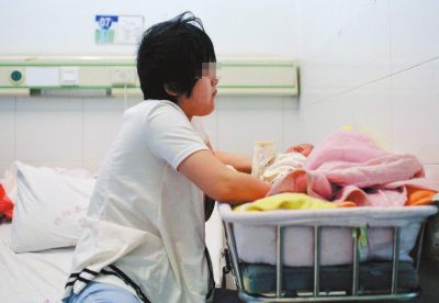 9月9日,湖南祁阳某医院内,思思将哭闹的孩子抱起。