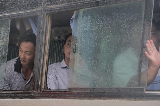 7月30日，在缅甸密支那，获释的中国伐木工人从大巴车上向外张望。 新华社发