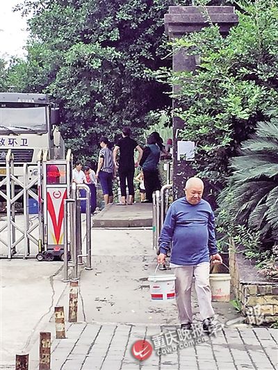 一位老人从环卫车上接到两桶水后步履蹒跚地提回家