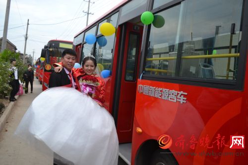 新郎把新娘抱上公交婚车。本报记者 王伟强 摄