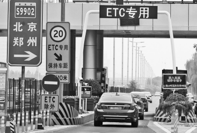 一輛輛汽車正快速通過高速公路上的ETC通道。新華社攝影