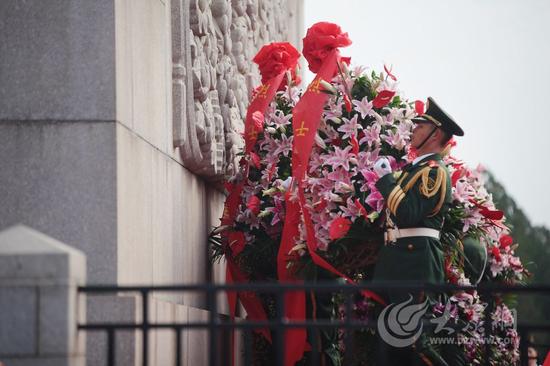 在济南市英雄山革命烈士纪念塔下，伴随着低沉而深情的《献花曲》，礼兵将花篮抬起，摆放在纪念塔基座上。大众网记者 王长坤 摄