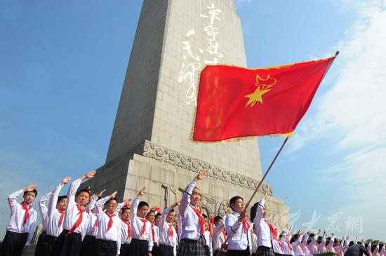 200名身着白衬衫、佩戴红领巾的少年儿童整齐列队，在革命烈士纪念塔前，高举右手、齐致队礼，表达继承革命烈士的光荣传统、为着理想奋勇前进的远大志向。大众网记者 王长坤 摄