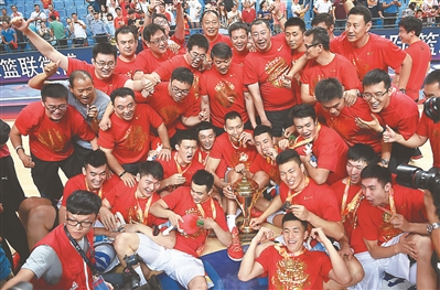 昨晚，在2015亚洲男篮锦标赛决赛中，中国男篮以78：67战胜菲律宾队，以全胜战绩重返亚洲篮坛之巅，在第16次夺得亚锦赛冠军的同时，也获得参加明年里约奥运会的资格。图为中国队队员和教练与冠军奖杯合影。 林华维/文 新华社发