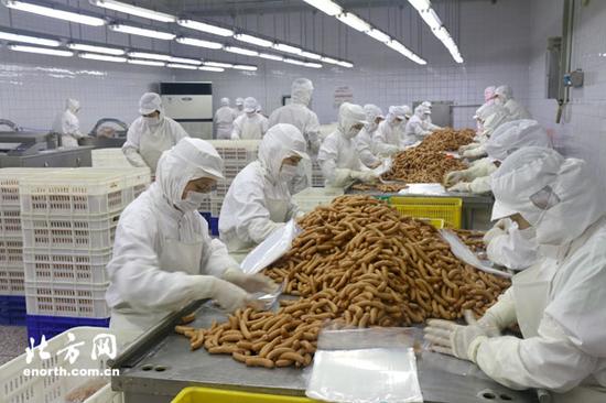 工人给熟肉制品分拣包装