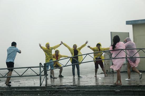 台风彩虹翻搅北部湾 游客不顾危险专程来玩风