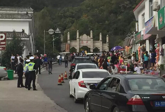 旅游車輛和游客有序地出入景區山門