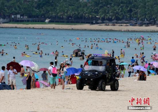 10月3日，国庆黄金周第三天，在知名的旅游城市海南三亚，警方在火车站、三亚湾、大东海等游人密集的场所进行武装巡逻，维护节日期间社会秩序，确保广大市民游客过一个安全有序的国庆假期。图为警方沙滩巡逻车在游�