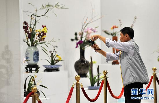 9月29日，第四届中国兰花大会在北京房山区长阳镇兰花文化休闲公园开幕。图为观众正在拍摄名贵兰花展品。