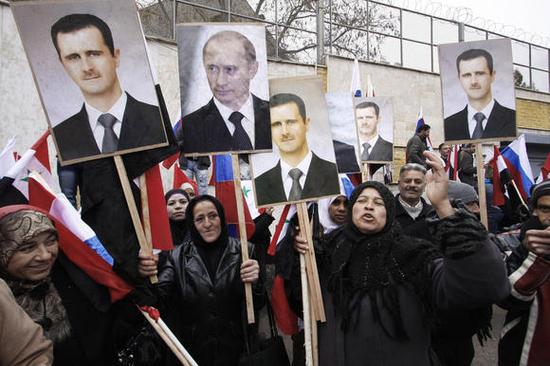 叙利亚民众手举叙总统巴沙尔和俄罗斯总统普京的画像集会。