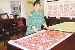 图为郭润芝正在讲解剪纸作品中的抗战故事