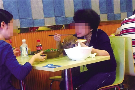中年女子与狗共用碗筷吃饭。