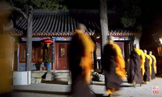 参加龙泉寺中秋传灯祈福法会的僧人走过寺院。新华社记者薛东梅摄