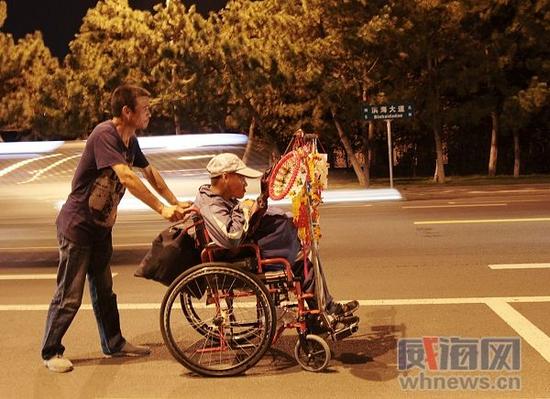 晚上八九點,父親推著張亞亮回家。