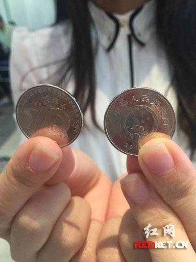 12日下午，长沙市民向记者展示兑换到的抗战纪念币。