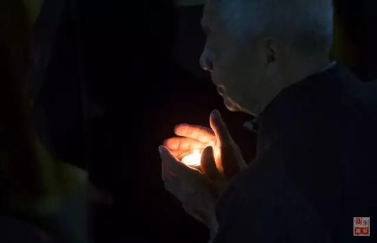 一名居士参加中秋传灯祈福法会。新华社记者孟晨光摄