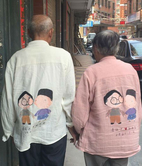 福建一对结婚近55年的老夫妻穿着卡通版情侣装，手牵手走在路上。