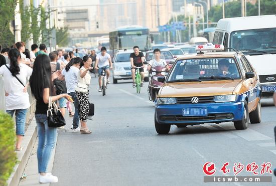 下班晚高峰时期，乘客往往等很久都难以搭乘到的士。长沙晚报记者 陈飞 摄