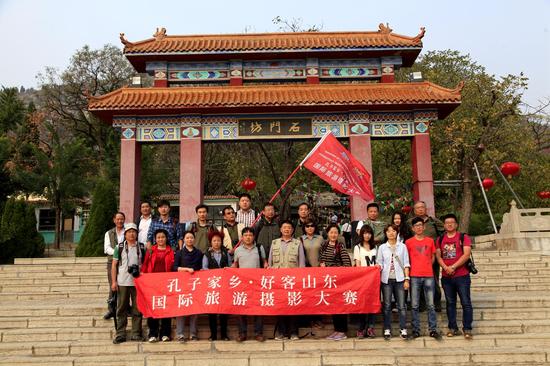 “孔子老家•好客山东”国际旅游摄影大赛采风团在石门坊景区门前合影