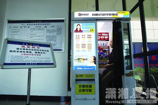 10月16日,株洲市泰山路派出所,市民在自带美颜功能的自助式证件照摄影机内拍摄证件照。图/潇湘晨报记者陈正