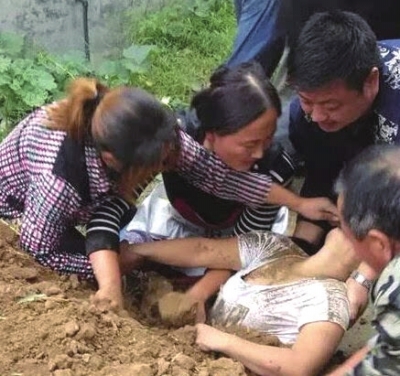 家属奋力挖出被埋亲人。