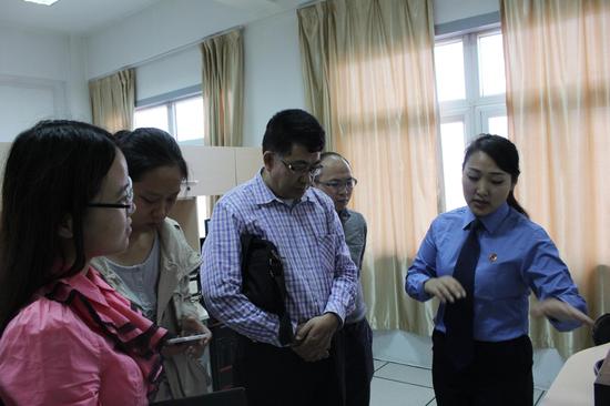 新鄉(xiāng)市技術(shù)處干警在位向記者團(tuán)介紹技術(shù)實驗室的相關(guān)情況