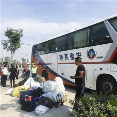 昨日,执法人员在查处一辆被拦截的旅游大巴。