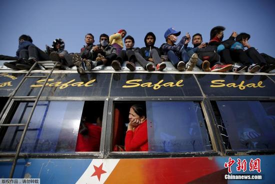 当地时间10月20日，尼泊尔加德满都，民众乘车回家庆祝德赛节。许多乘客由于车内已满，爬上公交车的车顶返家过节。
