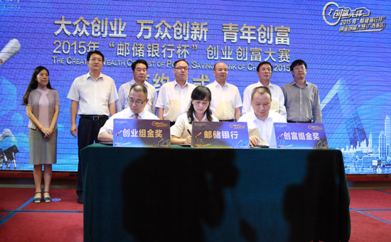 创业、创富组金奖选手代表与邮储银行广西区分行副行长梁玉锦签署贷款意向书,颁奖嘉宾共同见证