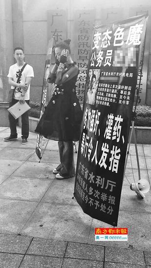 昨日上午，陈某在广东省水利厅门前拉起横幅“讨说法”。受访者供图