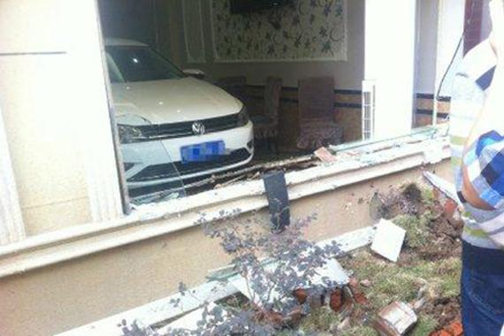 女司机倒车油门踩过头 轿车后退冲进酒店