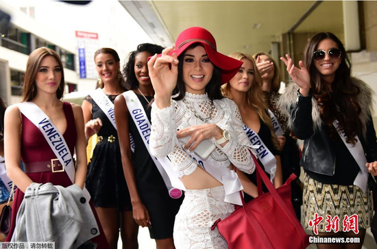 当地时间10月21日，在日本东京的伊势丹百货商店，参加国际小姐选美大赛的墨西哥小姐洛雷娜·塞维利亚和其他选手在抵达购物时微笑。2015国际小姐选美大赛将于11月5日在日本东京举行，将有来自70个国家和地区的佳丽参加这一赛事。