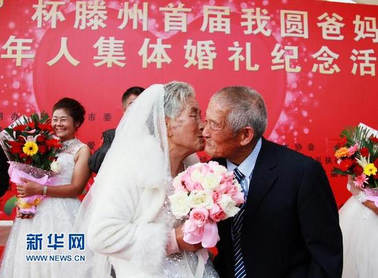 10月20日，86岁的柳西莲老人（前左）为84岁的老伴胡方荣献上深情一吻。（钟家增 摄）