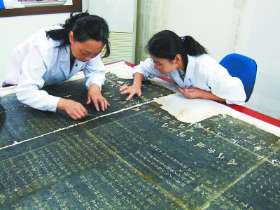河南博物院纸质研究室主任甘岚（左）在修复受损书帖。