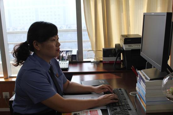 長期的伏案工作讓龐麗賢的頸椎出了問題，她將自己的電腦用書墊高從而緩解自己的頸椎問題