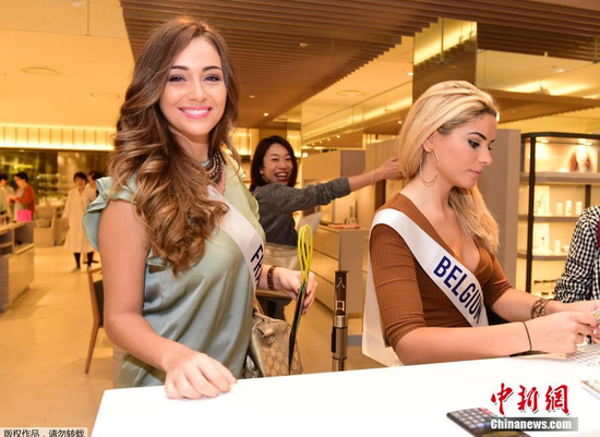当地时间10月21日，在日本东京的伊势丹百货商店，参加国际小姐选美大赛的墨西哥小姐洛雷娜·塞维利亚和其他选手在抵达购物时微笑。2015国际小姐选美大赛将于11月5日在日本东京举行，将有来自70个国家和地区的佳丽参加这一赛事。