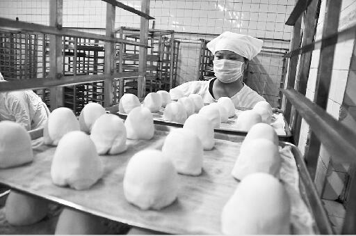 工人将揉成型的馒头摆放好，准备二次发酵。 记者李鹏飞 摄