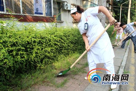 海南省人民医院组织120余名党员，对宿舍小区的卫生死角进行清理。(南海网记者陈望摄)