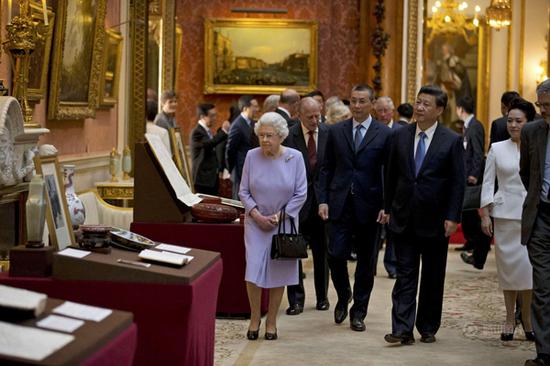 习近平在英国女王的陪同下来到白金汉宫，观看了英国王室收藏的中国文物