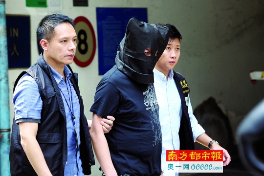 10月21日,警员带领一名疑犯到香港红磡案发现场重组案情,昨日法庭上一疑犯称“阻止暴力”,另一疑犯称没动手。 新华社发