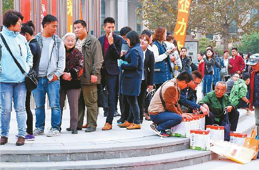 23日，在济南绿地中心门前，市民排队领商家免费赠送的牛奶。 记者王锋 摄
