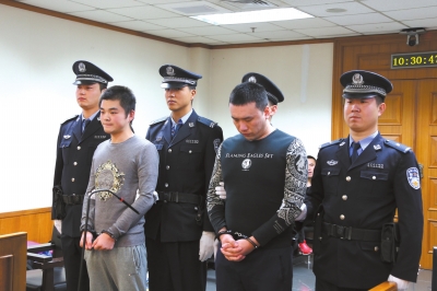 涉嫌故意伤害罪的李某(左)和陈某出庭受审。市一中院供图