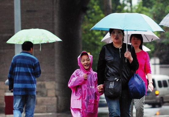 降雨天人们加衣保暖    本报记者沈继军摄