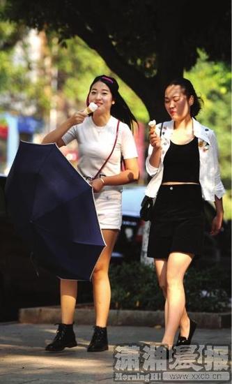 10月25日，中南林业科技大学校园内，两位着装清凉，吃着冰激淋的美女。图/记者杨旭