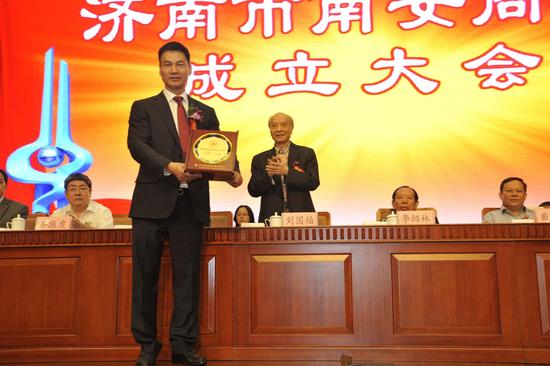 原山東省委常委、省軍區政委劉國福(右)為會長王曉明(左)授牌