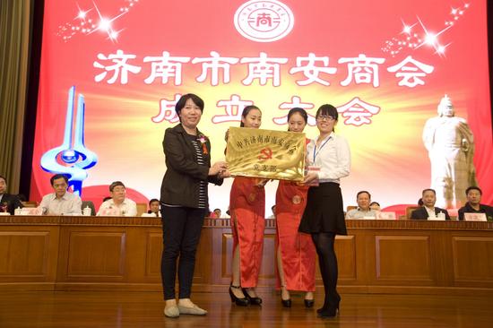濟南市民政局社會組織管理局管理處處長韓化莉(左)為商會黨支部授牌,商會黨支部書記吳曉娟(右)接牌